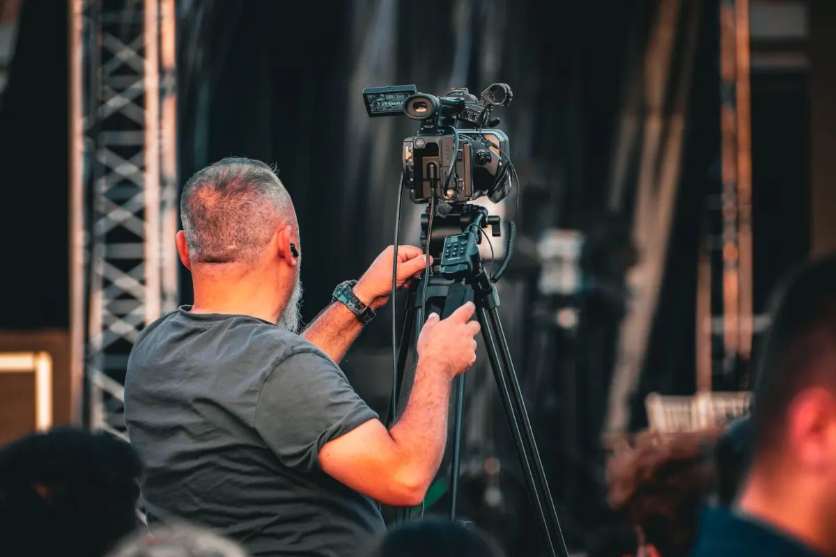 Una persona coloca una cámara en un trípode, el tipo de sesión enfocada que describe esta sección para el batching de video.