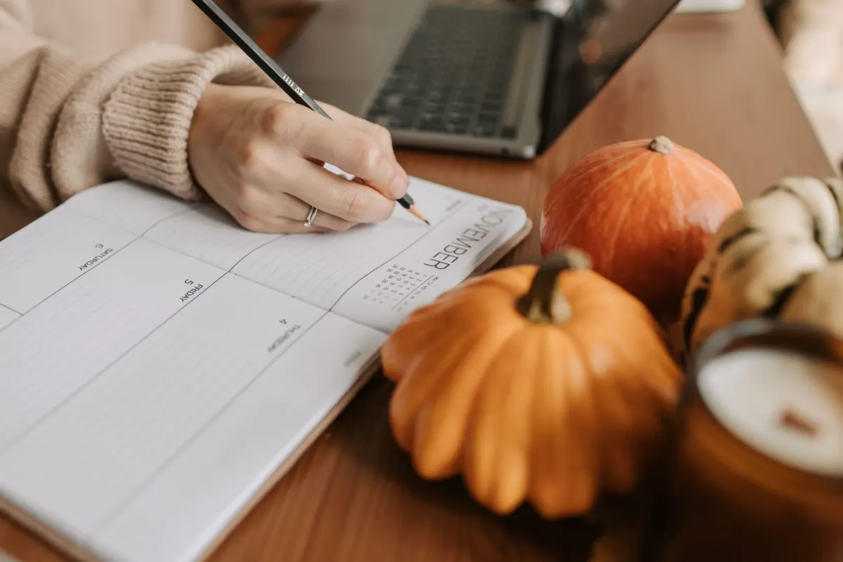Uma pessoa planeja uma semana de posts nas redes sociais em um calendário no laptop, o tipo de fluxo de trabalho que essas ferramentas de agendamento foram criadas para acelerar.