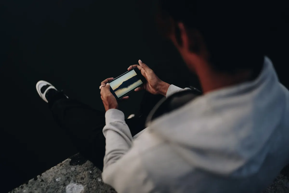 Une personne fait défiler son téléphone pendant sa pause déjeuner, le créneau de midi qui correspond au pic d'activité sur Facebook.