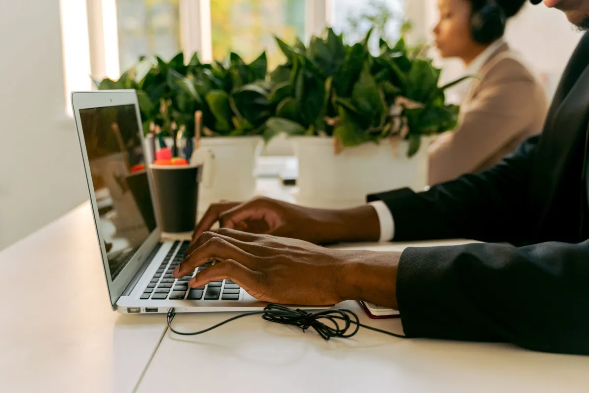 Eine berufstätige Person tippt morgens am Laptop, passend zur Aktivität während der Geschäftszeiten, die das LinkedIn-Engagement antreibt.