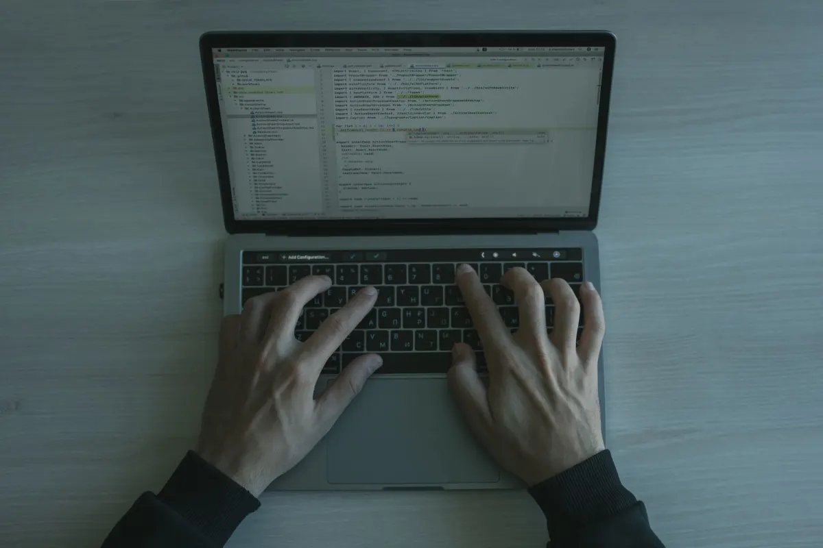 Un développeur tape du code sur un ordinateur portable, le genre de correctif JavaScript rapide qui casse silencieusement les décalages d'octets sur du texte non ASCII.