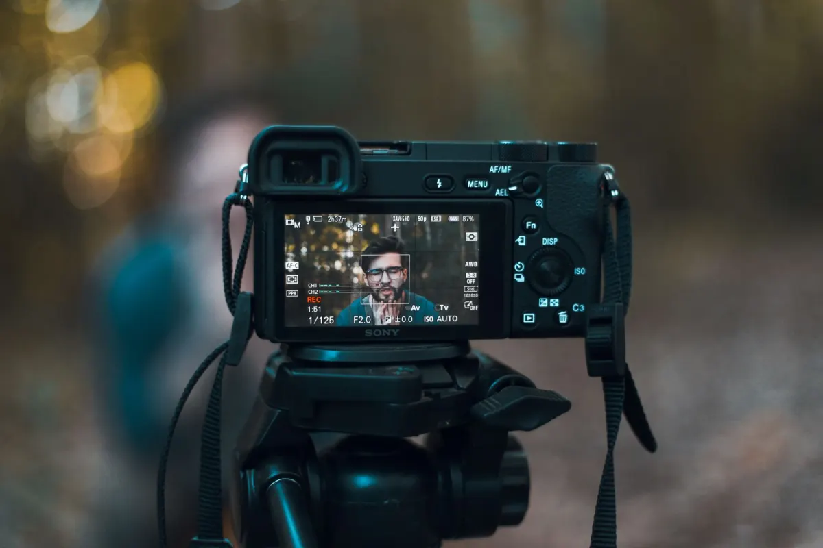 Um fotógrafo revisa as configurações de exportação na tela de uma câmera, relevante para escolher as dimensões certas antes de postar.