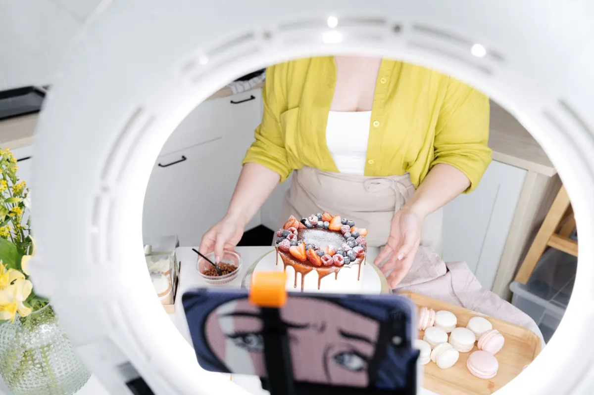 Un boulanger photographie une pâtisserie fraîche sur le comptoir pour une publication sur les réseaux sociaux.