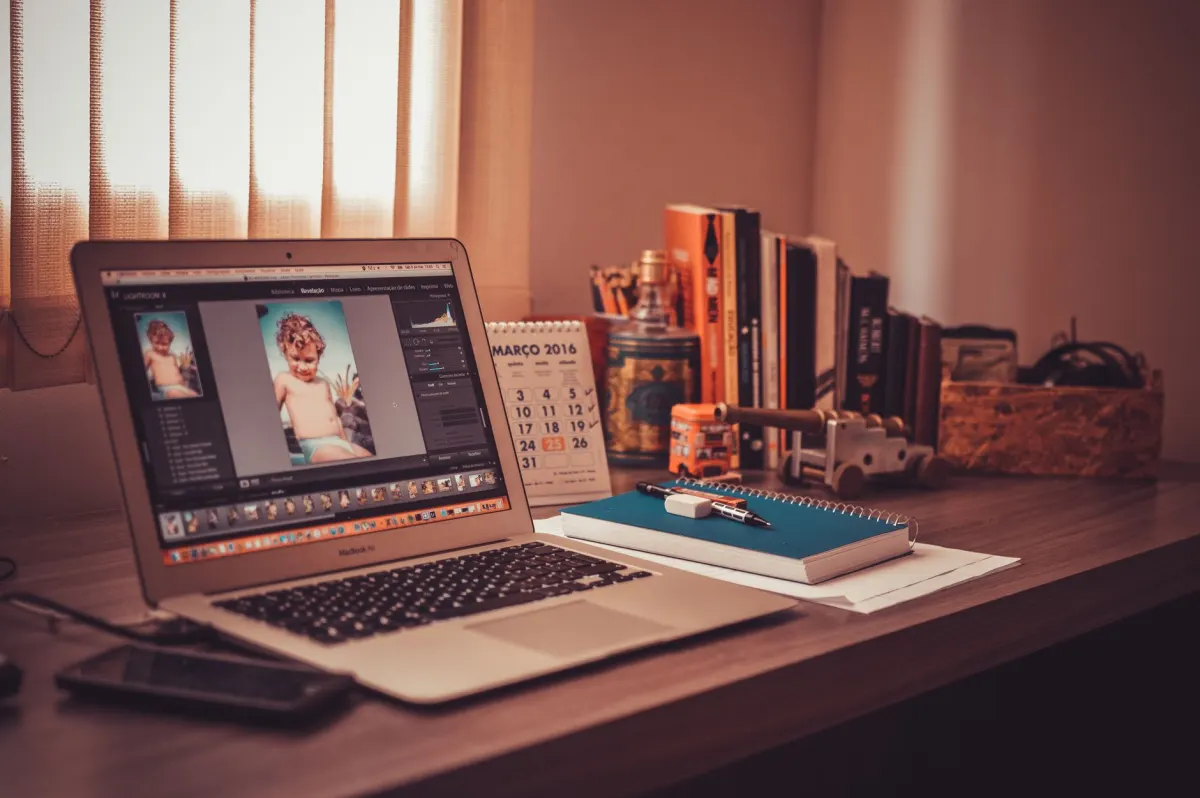 Eine Person bearbeitet Fotos im Stapel und plant einen Content-Kalender am Laptop, passend zum Massenplanungs- und KI-Bild-Workflow in diesem Abschnitt.