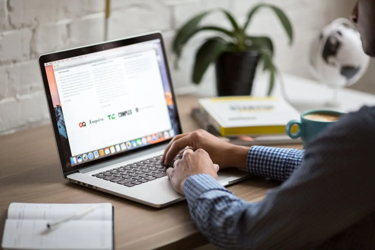 Uma pessoa lê uma mensagem em um laptop com expressão preocupada, o momento em que uma equipe decide se uma reclamação precisa de uma resposta personalizada.