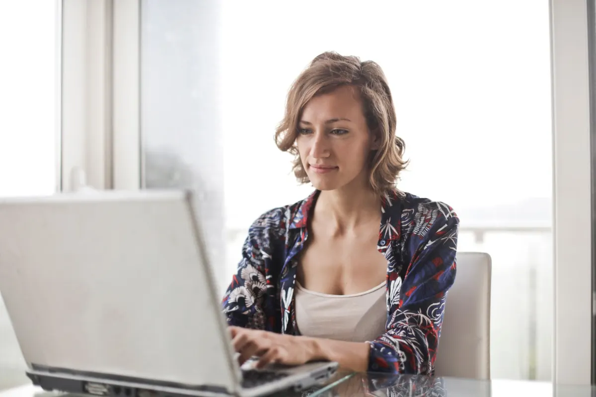 Eine Person tippt einen Kommentar auf einem Laptop, die Art von schneller Interaktion, die Faktoren wie Timing und Kommentartiefe beeinflussen.