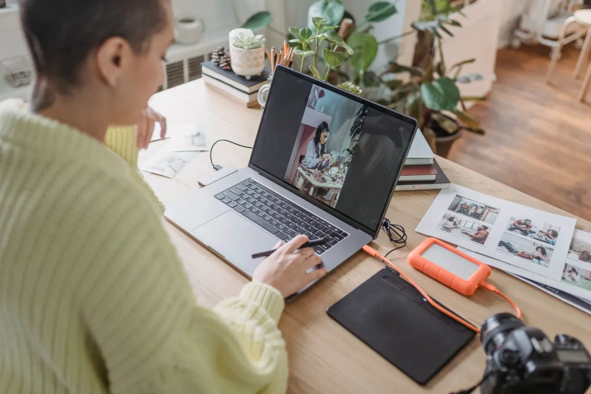 Un fotógrafo revisa material en un portátil, el tipo de trabajo de producción que define el oficio de un creador de contenido.