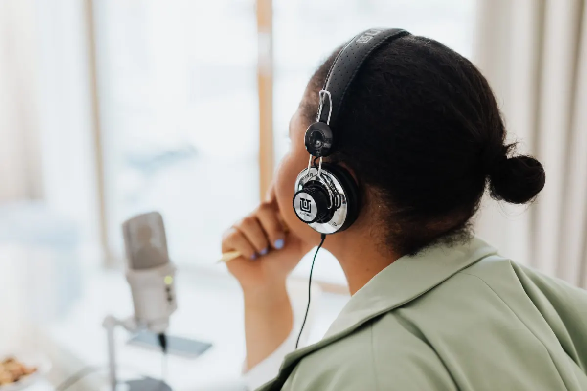 Une personne écoute un podcast au casque, illustrant le format audio que certaines audiences préfèrent.