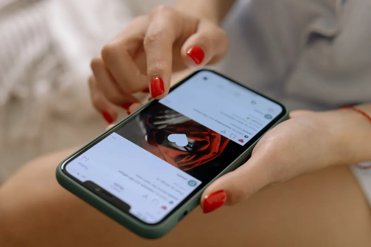 Eine Hand scrollt auf einem Smartphone durch einen Social-Media-Feed, passend zur Bedeutung der Mobile-Optimierung für die CTR.
