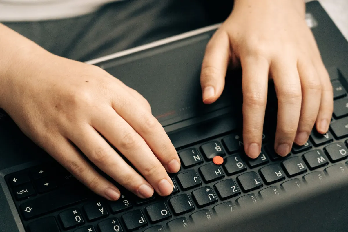 Una persona escribe en el teclado de una laptop, mas rapido que abrir un menu de formato.