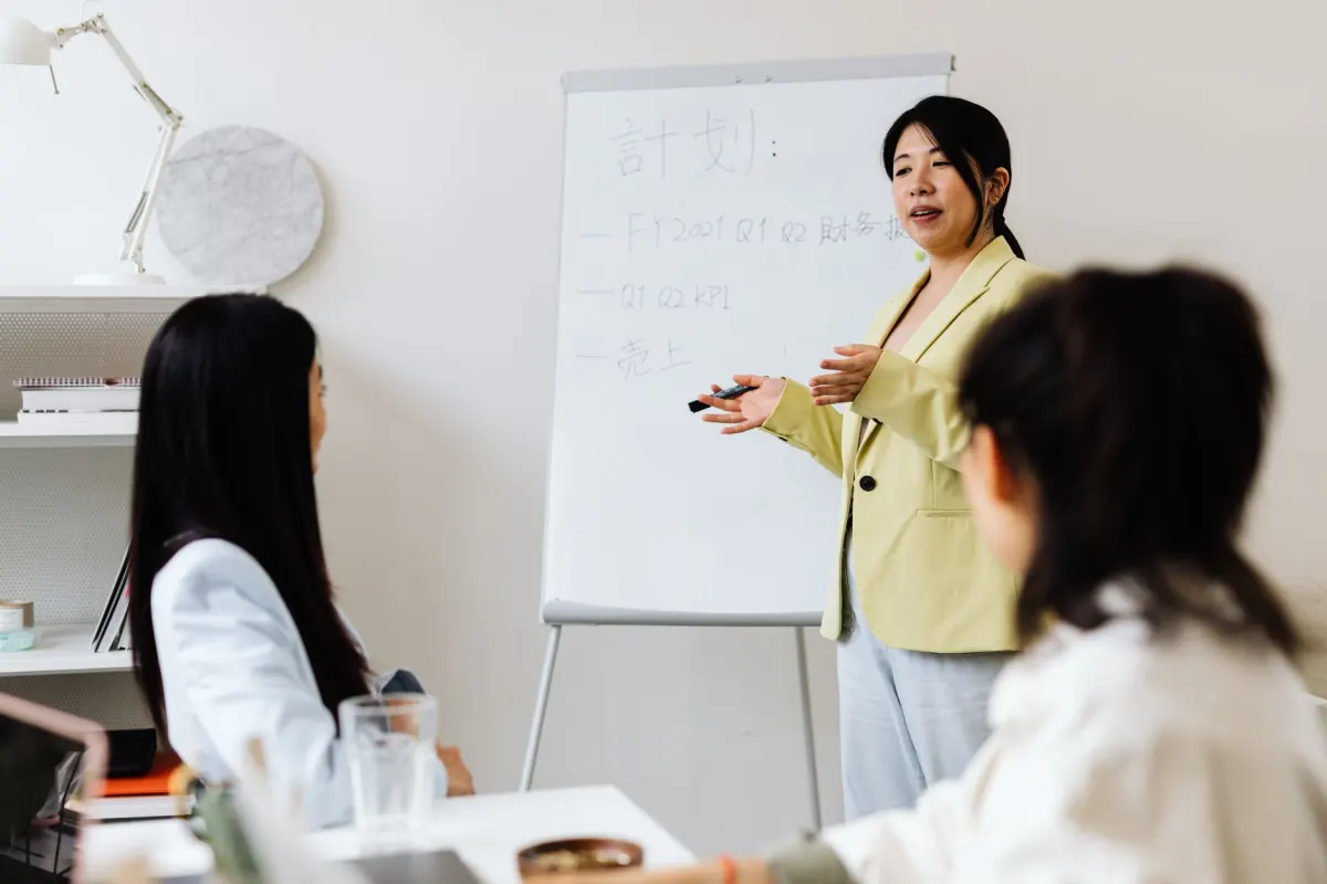 Marketing- und Vertriebsmitarbeiter besprechen an einem Whiteboard, wo Leads abspringen, im Zusammenhang mit häufigen Demand-Waterfall-Fehlern.