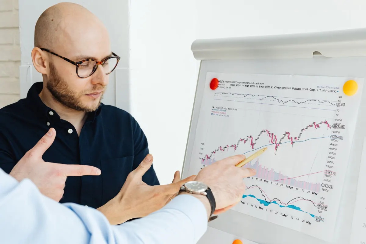 An analyst studies trend charts on a wall, illustrating how listening data gets combined with monitoring for a fuller picture.