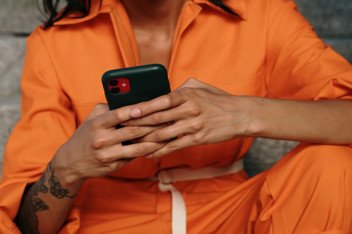 Uma mão toca em um link compartilhado dentro de um app de mensagens, um dos compartilhamentos privados que o rastreamento de dark social tenta captar.