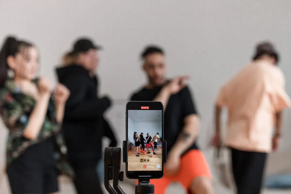 Eine Hand hält ein Smartphone und nimmt ein vertikales Video auf, was für Inhaltsformate steht, die zu Plattformen wie Instagram und TikTok passen.