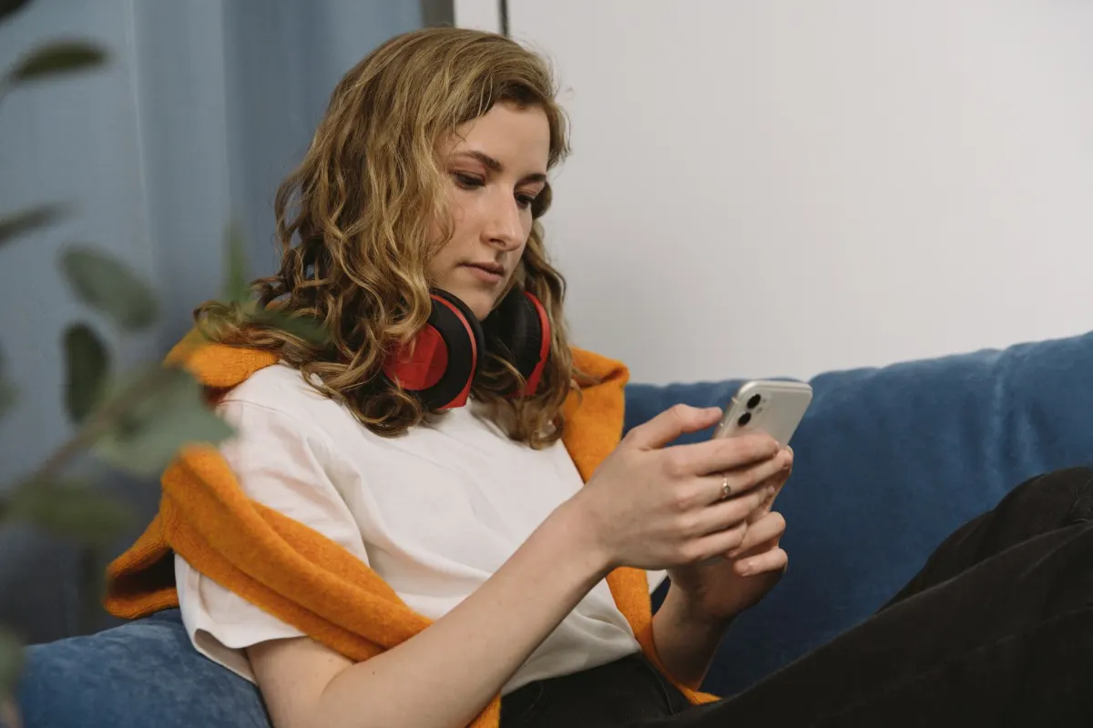 Uma mulher confere as curtidas no celular logo após publicar, a reação rápida em que os pods se apoiam.