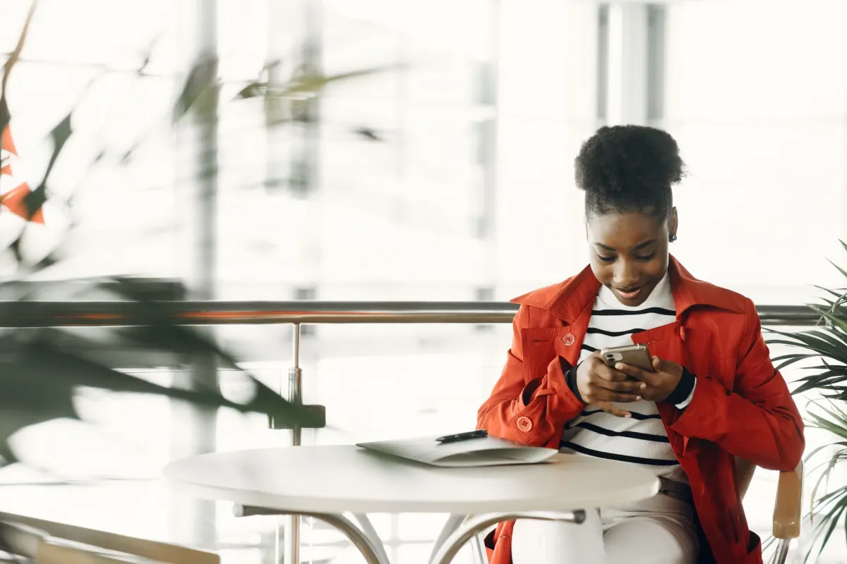 Une femme consulte des chiffres sur son téléphone, en lien avec la section sur les plages habituelles de taux d'engagement.