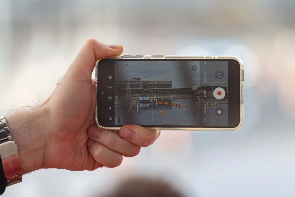 Ein Smartphone filmt eine Person auf der Straße, genau die Art von Aufnahme, für die die Deepfake-Offenlegungspflicht gilt.