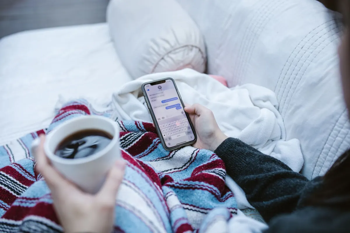 Eine Frau beantwortet Nachrichten auf ihrem Handy, was die Priorisierung verschiedener Kommentartypen widerspiegelt.