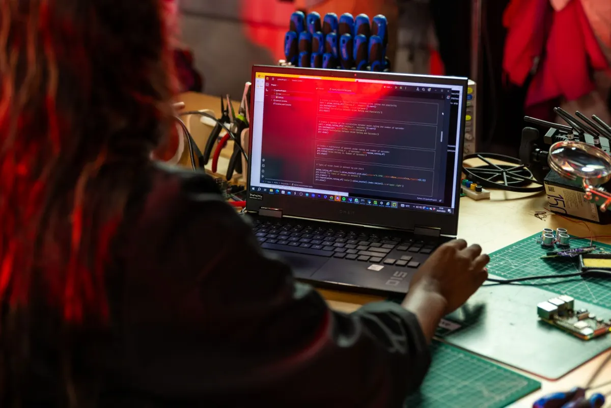 A magnifying glass held over lines of code on a screen, evoking the log inspection needed to catch traffic bursts.