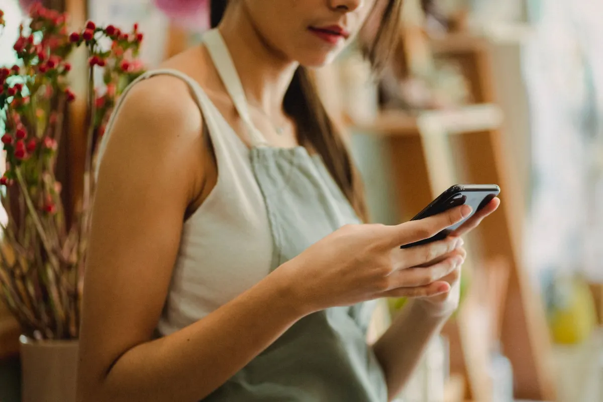 Un pequeño empresario revisa su teléfono, en representación de las marcas que aprenden a participar de forma auténtica en nuevas plataformas.
