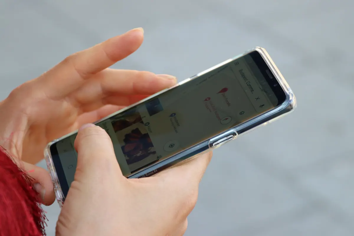 Eine Person nutzt eine Website auf dem Handy, was zeigt, wie ein mobiler Browser das Desktop-Meldeformular erreichen kann.
