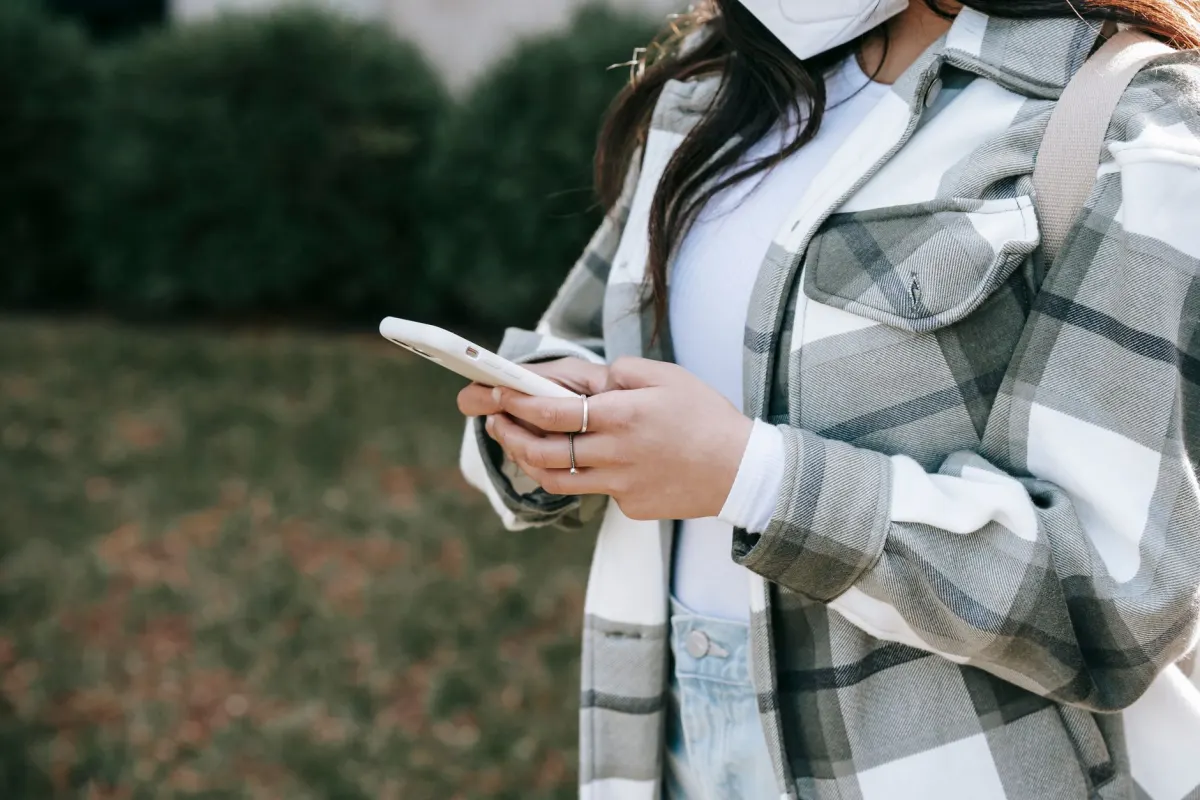Ein Reisender scrollt im Freien auf seinem Handy und steht stellvertretend für die Zielgruppe, die Hotels auf ihren wichtigsten Social-Media-Plattformen erreichen möchten.