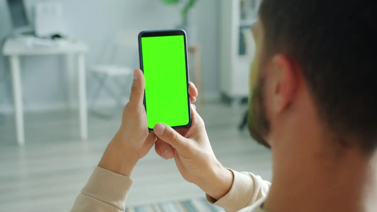 Une personne consultant des chiffres sur son téléphone, illustrant la façon dont les créateurs vérifient leurs propres estimations de paiement.