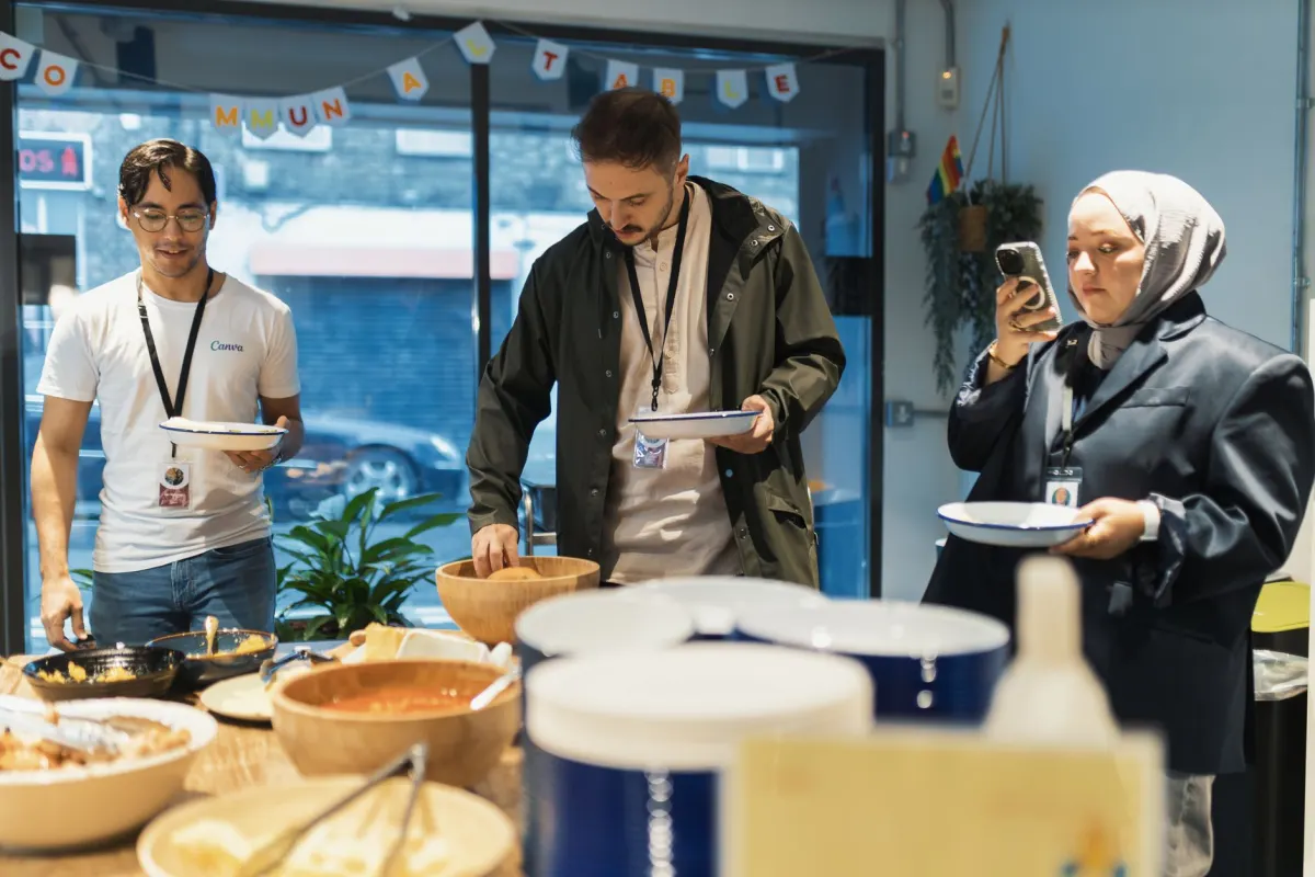 Une equipe partageant une pause dejeuner improvisee au bureau, le genre de moment ordinaire qui rend l'histoire d'une marque authentique.