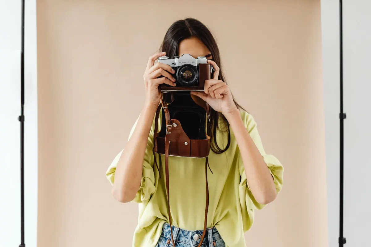 Ein Fotograf richtet ein Produktshooting für handgefertigte Lederwaren ein, eine Art von Content-Produktionskosten, die in der Gesamtinvestition der Kampagne berücksichtigt wird.