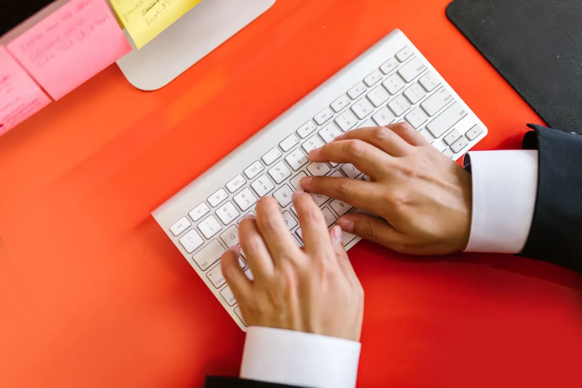Eine Person tippt an einem Desktop-Computer, passend zu den Schritten zum Anheften eines Beitrags im Desktop-Browser.