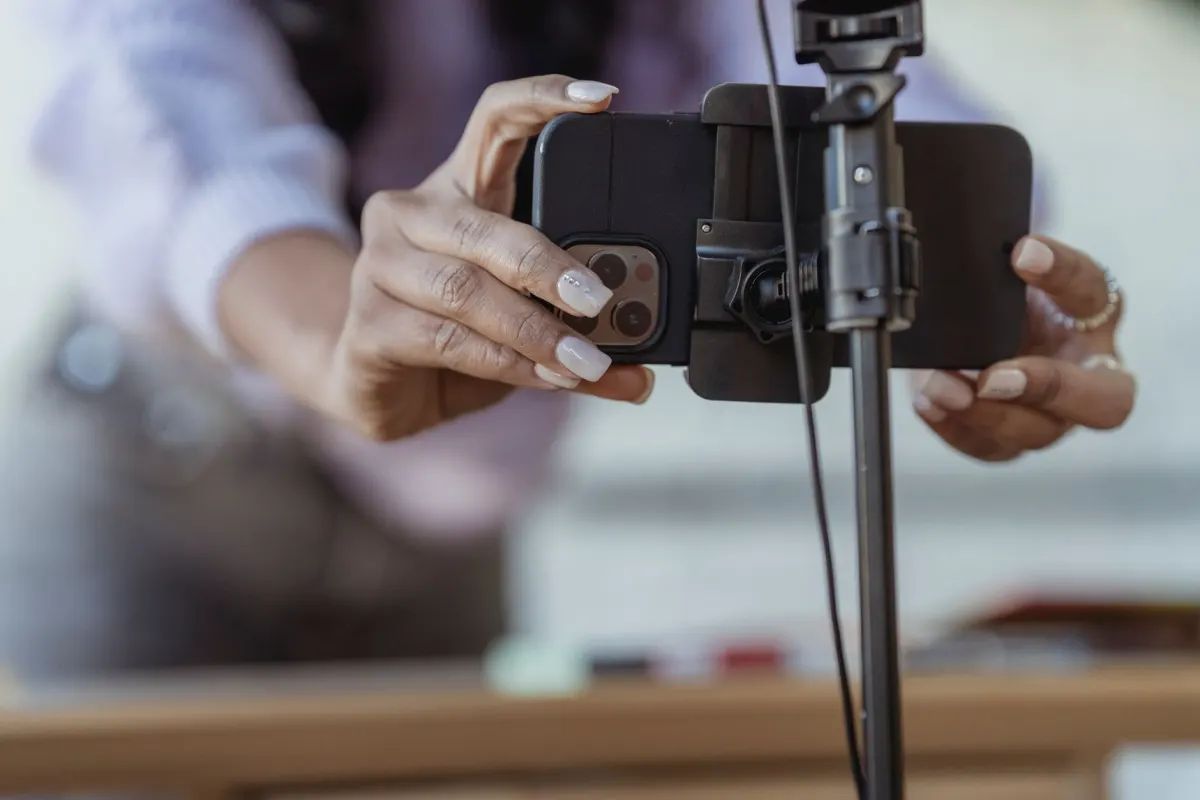 Eine Person hält ein Smartphone hochkant, um ein kurzes Video aufzunehmen, wie beim Filmen von Reels am Handy.