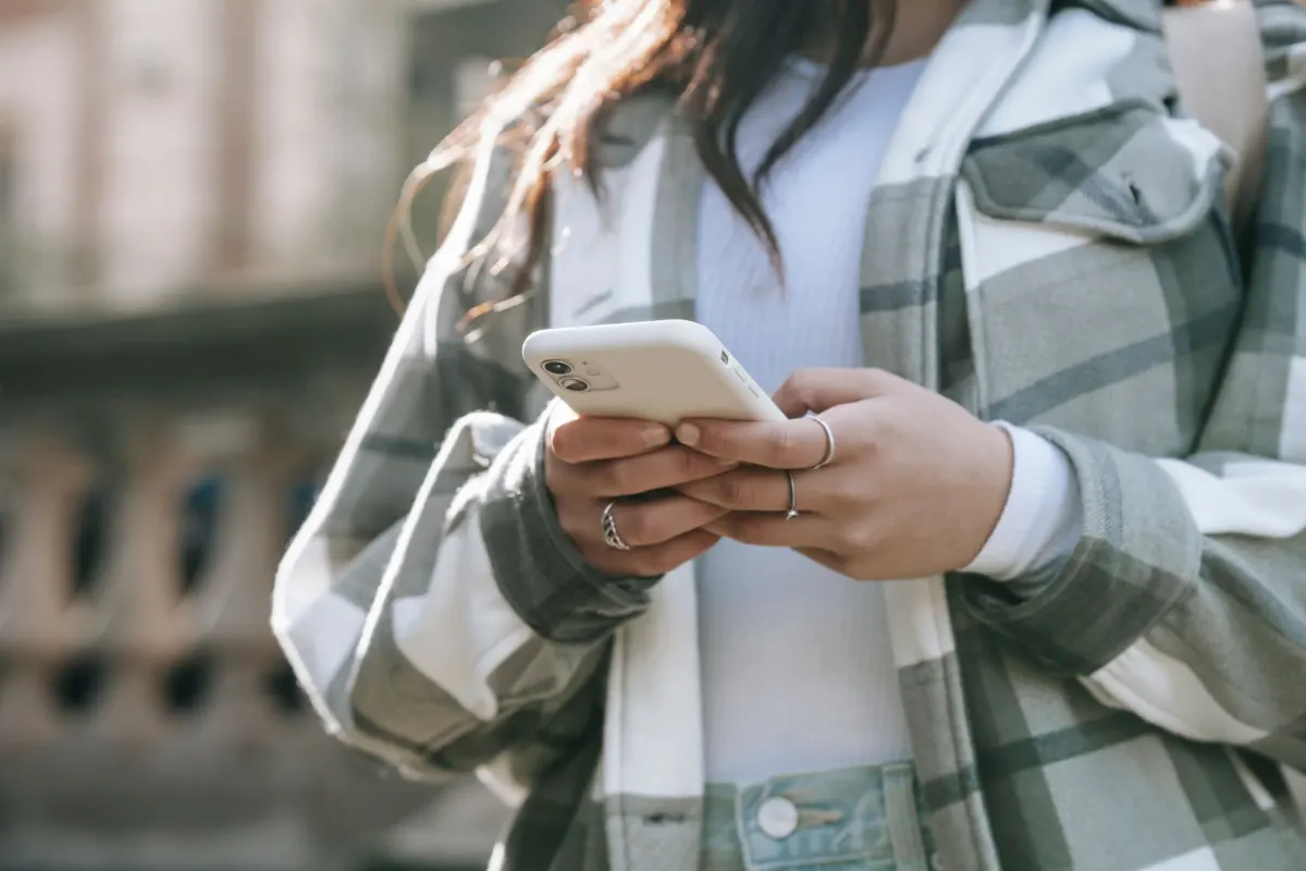 A person reads a notification on their phone, standing in for checking API usage headers after a call.