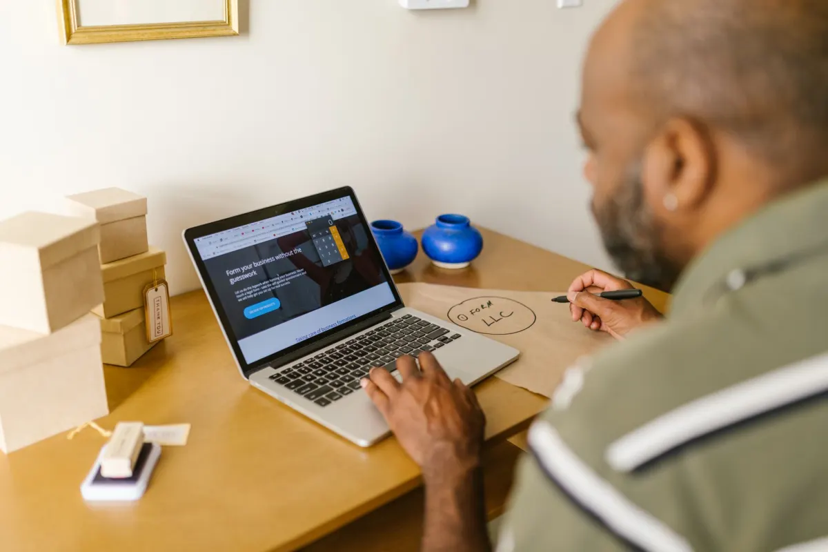 A small business owner works at a laptop, the kind of setup an app review screencast has to capture on camera.