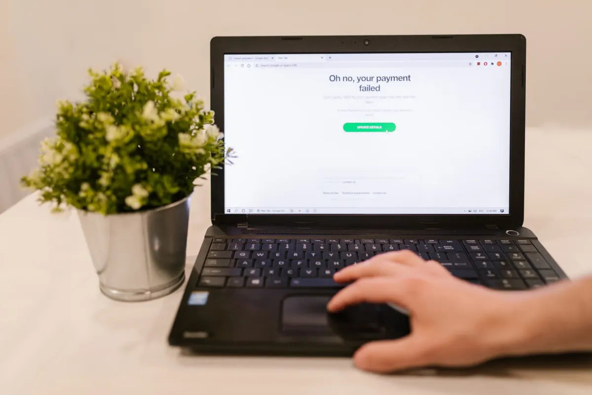 A person at a laptop looking at an error message while editing a video file, reflecting the troubleshooting work an ERROR status_code demands.