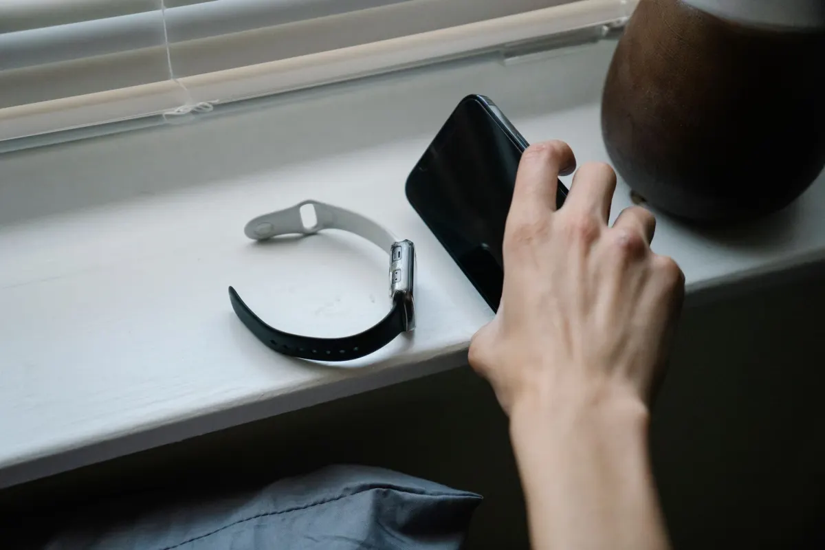 Eine Person prüft eine Benachrichtigung auf dem Handy, ein Moment, der dem Abfragen eines Containers auf den fertigen Status entspricht.