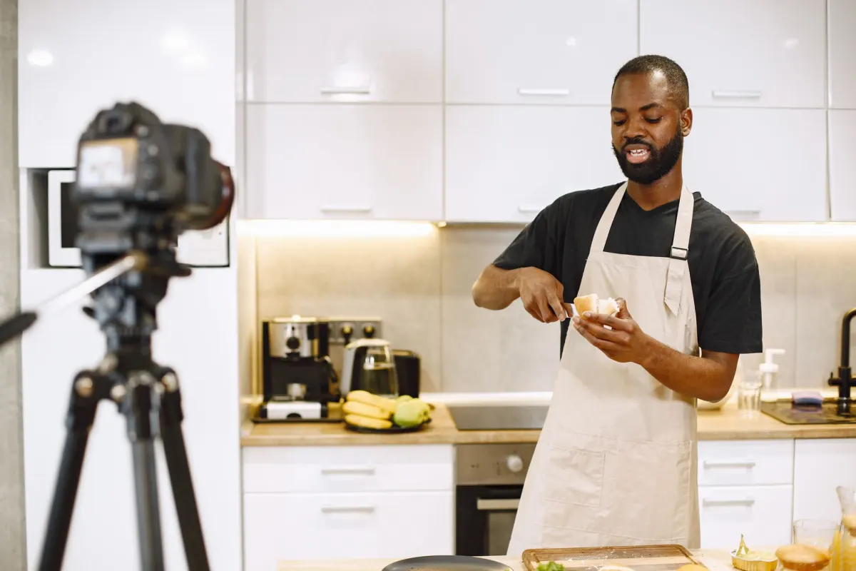 Un cocinero filma un tutorial de receta con un teléfono montado en un trípode, el tipo de contenido tutorial más largo que se beneficia de un límite de Reels ampliado.