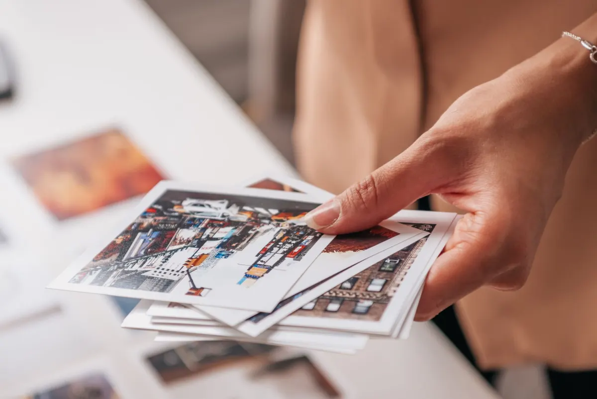 Ein Fotograf legt ausgedruckte Fotos auf einem Tisch aus, um einen stimmigen visuellen Feed zu planen.