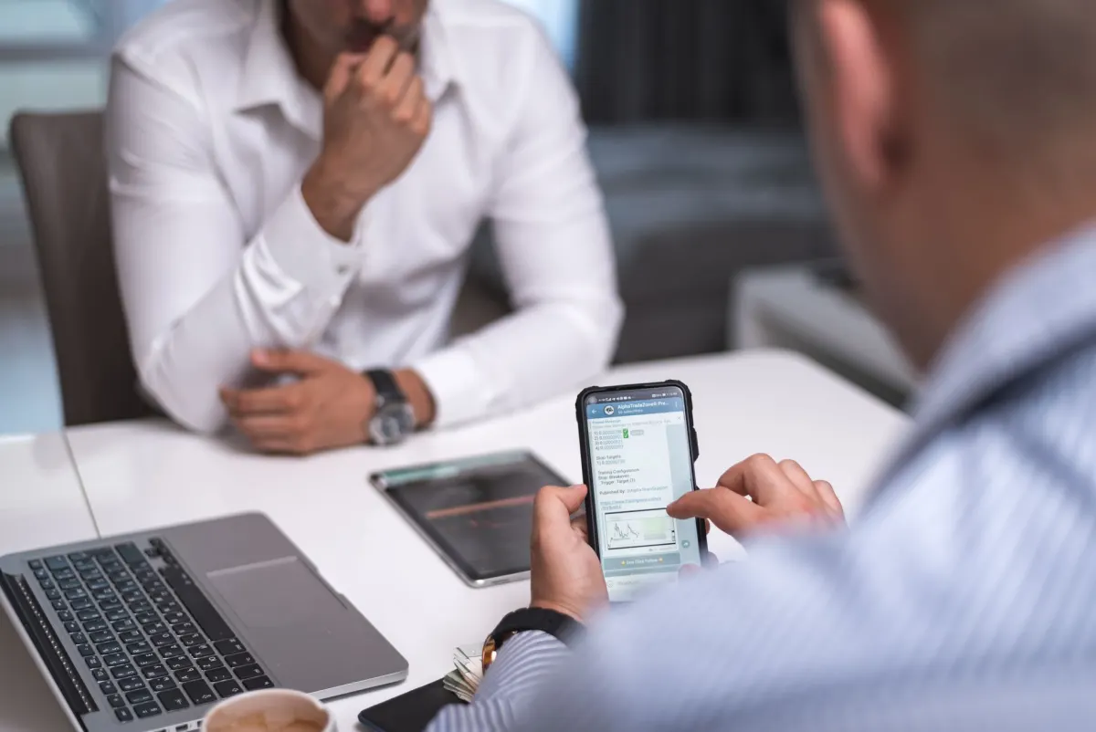 Eine Fachkraft scrollt im Büro auf dem Handy, ein Sinnbild dafür, wie LinkedIn und Facebook dieselbe Person unterschiedlich ansprechen.