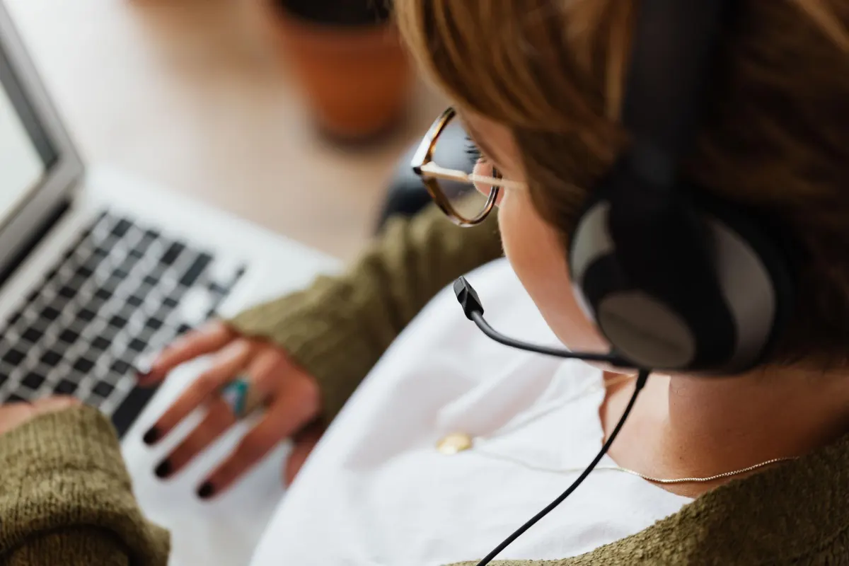 Una persona usa un portátil con auriculares, una imagen que representa cómo los lectores de pantalla dependen del texto alternativo para describir imágenes en la app de LinkedIn.