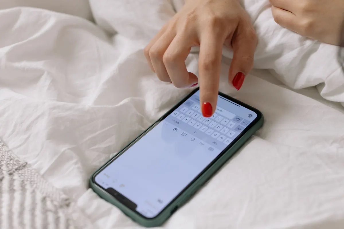 Une femme tape un message sur son téléphone, en lien avec le message privé envoyé avant de faire une présentation.