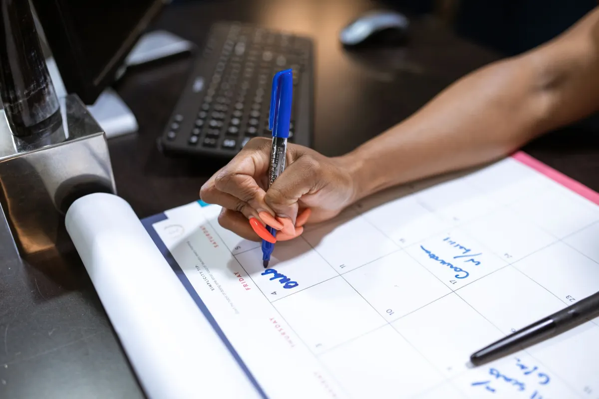 A pen resting on an open desk planner, standing in for a post that waits on your side until its scheduled time.