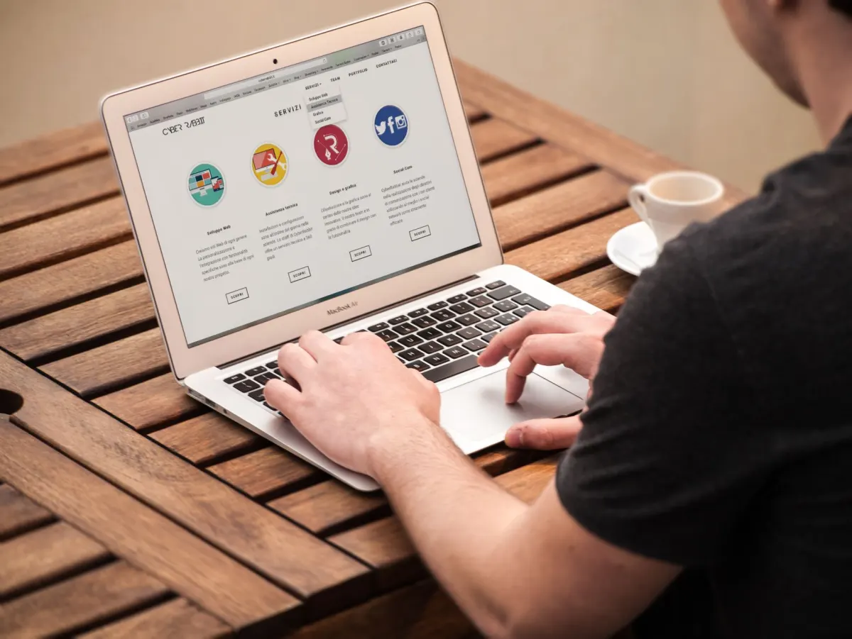 Um gestor de redes sociais agenda publicações para várias páginas pelo laptop.