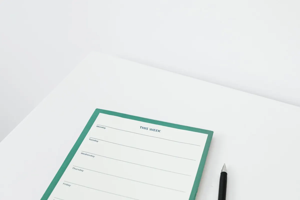 A paper weekly planner on a desk with a pen, standing in for the weekly LinkedIn posting cadence.