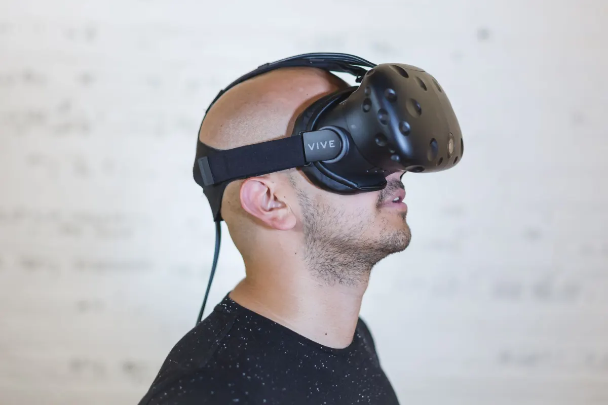 Une personne porte un casque de réalité virtuelle dans une pièce lumineuse, illustrant les outils immersifs abordés dans cette section sur l'immersion du public dans l'histoire.