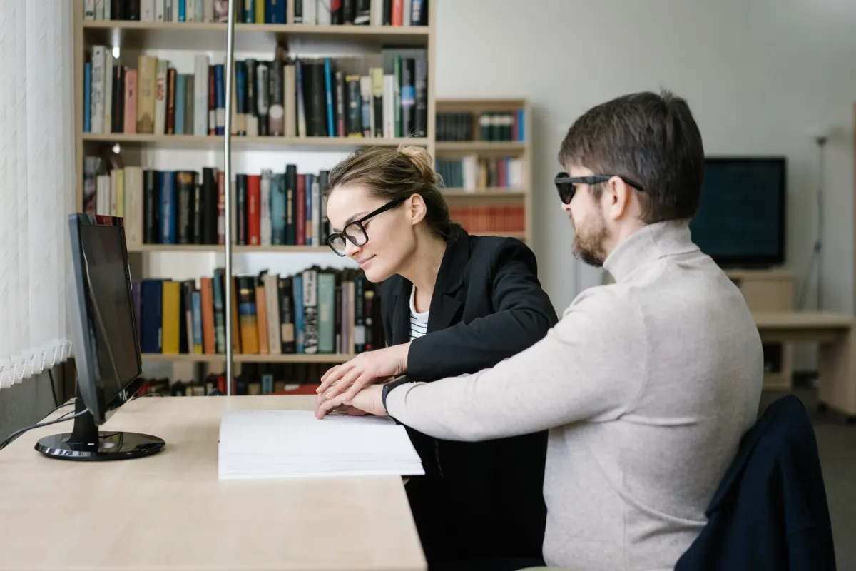A visually impaired person works at a computer, the kind of reader who relies on image descriptions.