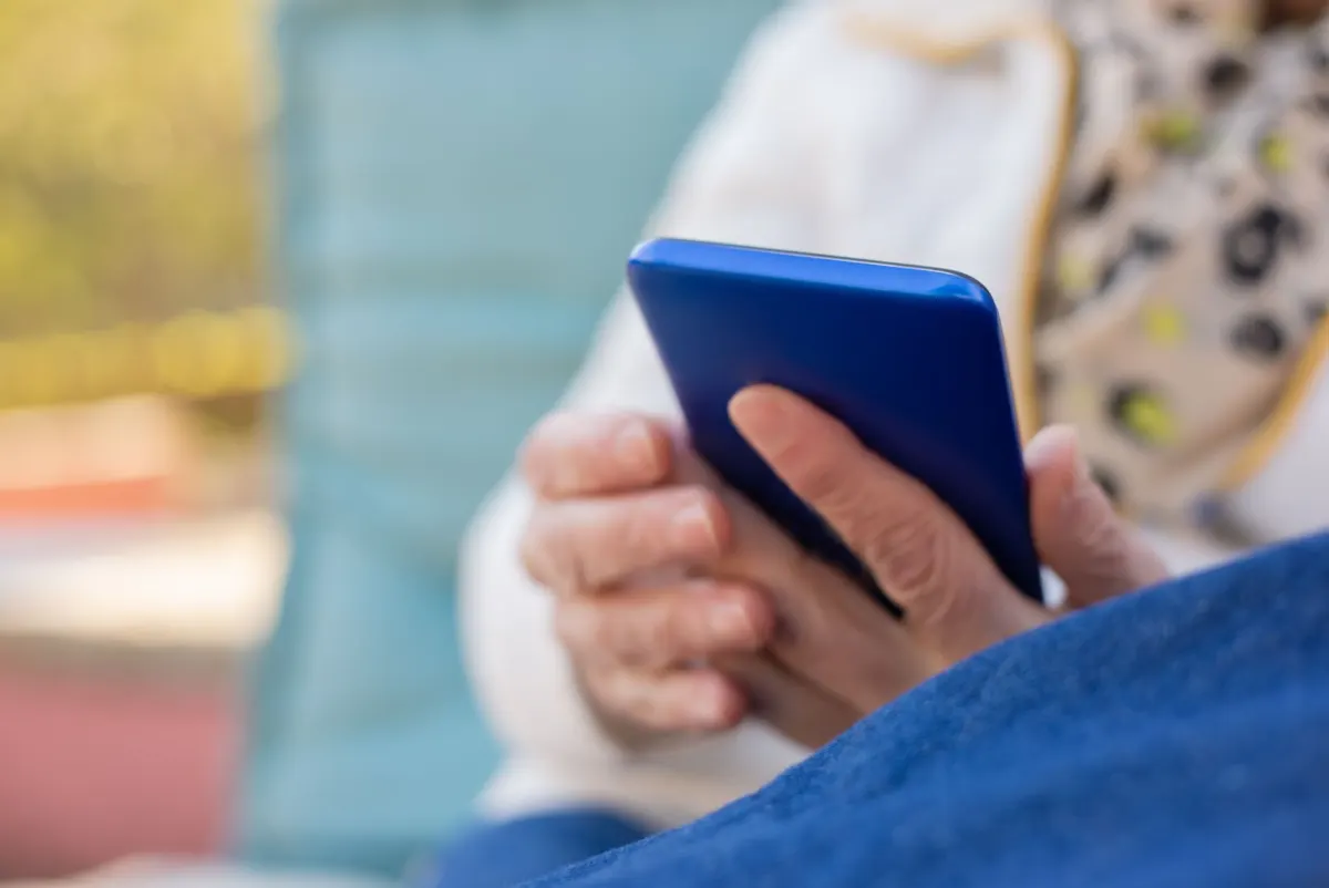 Eine Person scrollt im Freien auf einem Smartphone, neben dem Abschnitt, der die Echtzeit-Reichweite von X mit dezentralen Alternativen vergleicht.