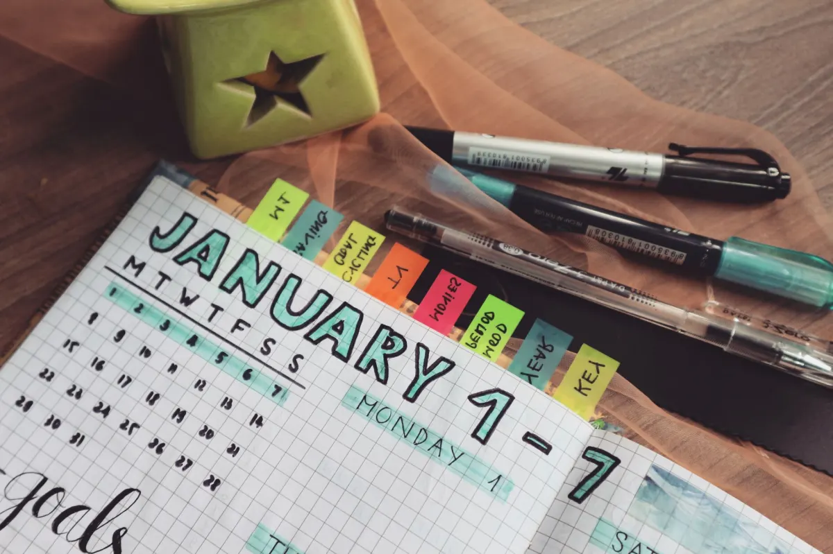 A wall calendar with handwritten marks shows a weekly schedule, the rhythm behind a recurring post.