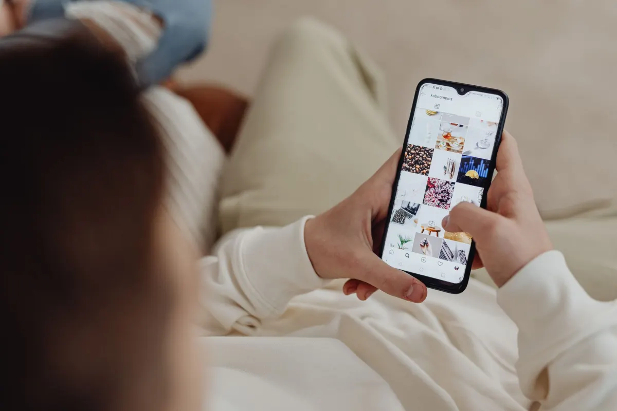 Uma pessoa rolando o feed social no celular, o momento em que um post promovido precisa parecer apenas mais uma publicação.