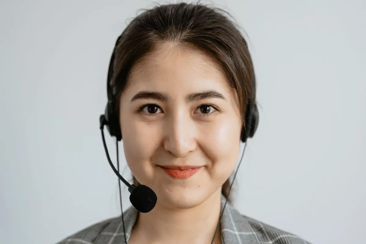 Eine Support-Mitarbeiterin mit Headset beantwortet an ihrem Schreibtisch Nachrichten, eine Aufgabe, die ein reines Scheduling-Tool nicht abdeckt.