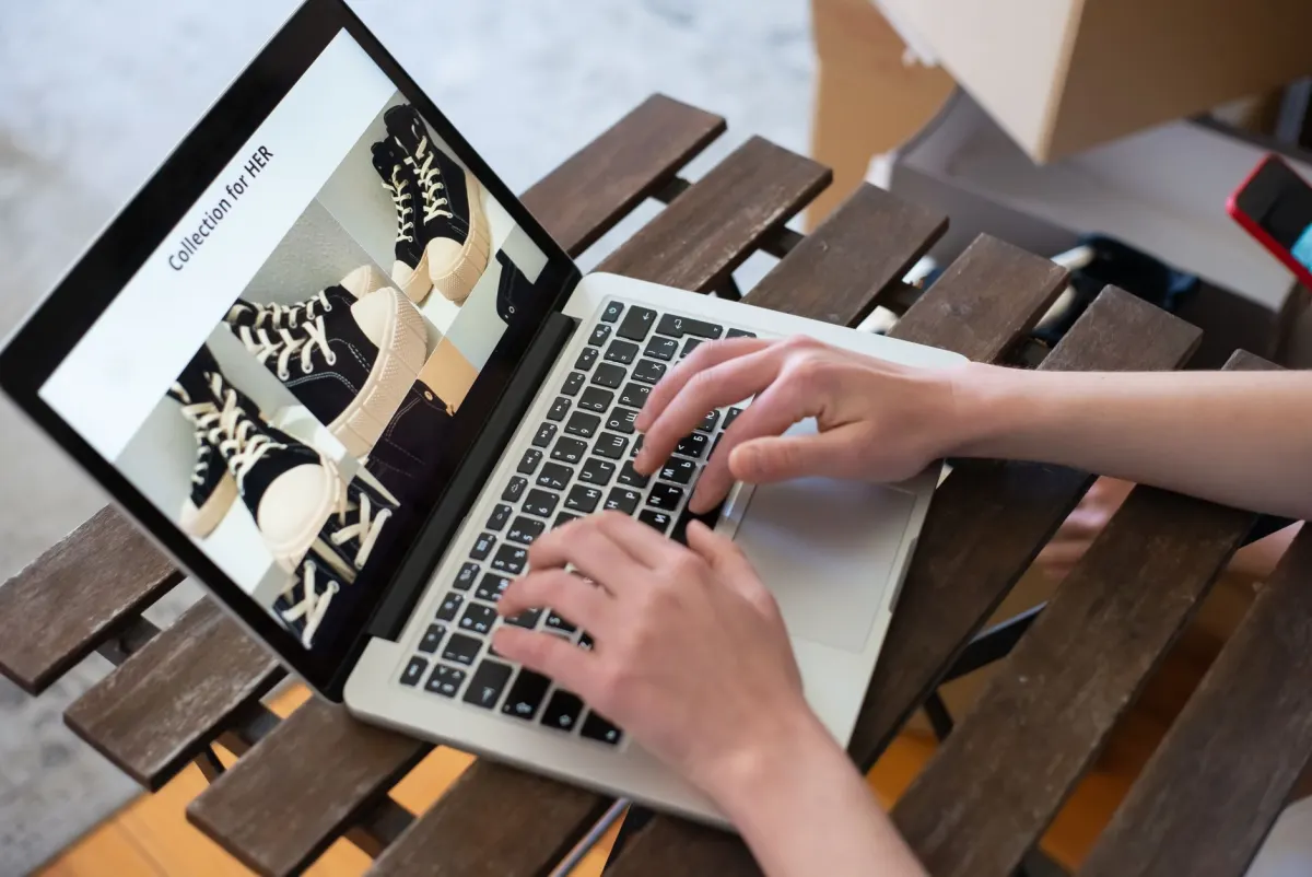 Uma mulher navega por páginas de produto no laptop, o tipo de comportamento no site que sinaliza intenção de compra.